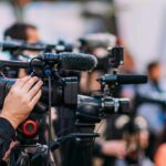 Oil Lever Pulled: Wallets Scream Next Video cameras on tripods at a media event