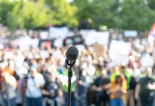 Justin Bieber Gives Fans Unexpected Park Concert Microphone on a stand facing a large blurred crowd