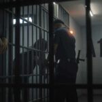 Parole Door Swings Wider at 50 police officer at a jail cell with detainees behind bars