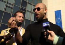 Two men speaking to reporters with microphones outside a modern building