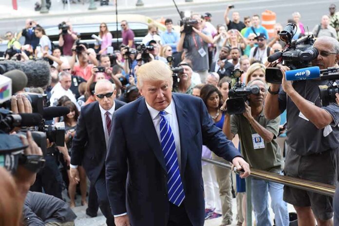 shutterstock_307005071 Donald Trump walks up steps through a crowd as A. J. Calloway films nearby