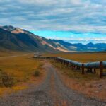 Major Oil Lifeline Goes Temporarily Offline Pipeline crossing a broad valley with mountains under a cloudy sky
