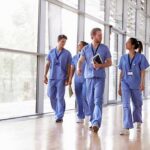 Kia Nurse walking with fellow medical staff in hospital corridor