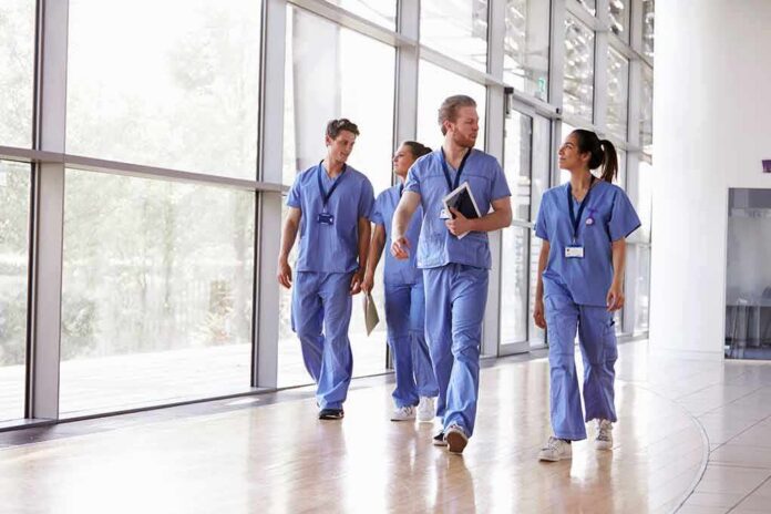 Kia Nurse walking with fellow medical staff in hospital corridor