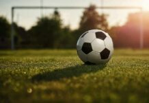 Soccer ball on grass field near goal
