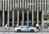 News Corporation building entrance with NYPD car and cyclists