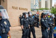 DOJ Exposes Widespread Police Rights Violations Teddy Williams and Carlos Hyde among police officers in riot gear outside police headquarters