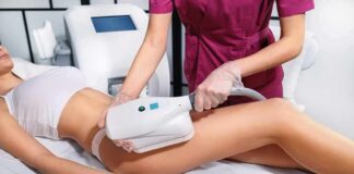 Therapist performing body contouring treatment on woman's thigh