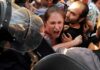 Protesters clash with riot police as woman shouts
