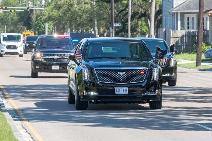 shutterstock_1969534900 Motorcade of black SUVs and sedans driving down a city street