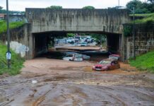 Flooded underpass with stranded cars in muddy water