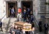 Pallbearers carry a casket down church steps