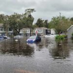 Flooded residential street with partially submerged cars