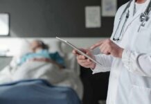 Surgery Error Leaves Woman Without Both Legs Doctor using tablet beside hospital patient