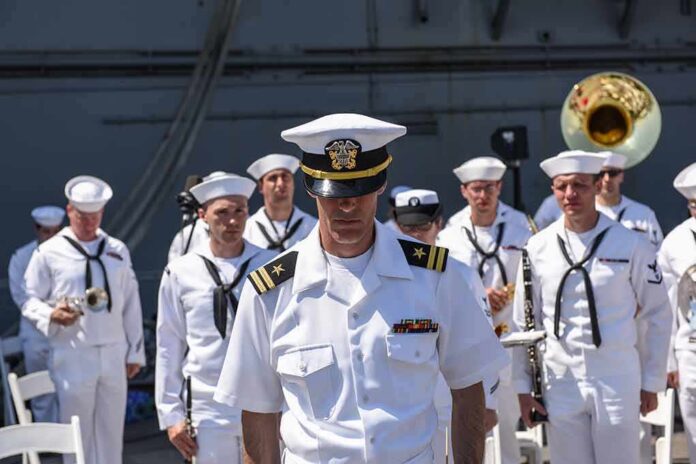 shutterstock_281914421 naval officer in white uniform stands before a military band