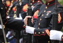 Marines in dress uniforms holding rifles during a ceremony