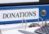 Hundreds of Complaints Raise Alarms in NYC Schools Blue binder labeled donations on a desk with papers and a calculator