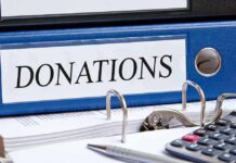 Hundreds of Complaints Raise Alarms in NYC Schools Blue binder labeled donations on a desk with papers and a calculator