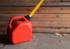 Red gasoline can with yellow spout on a garage floor