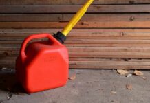 Red gasoline can with yellow spout on a garage floor